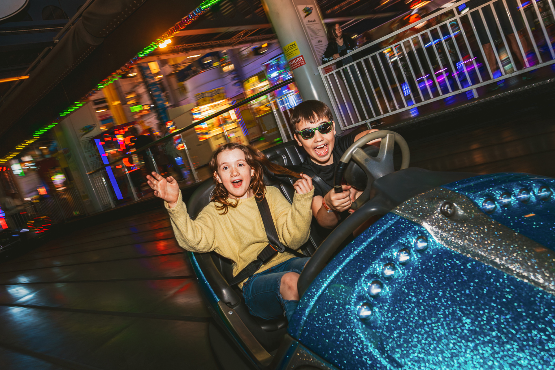 Two children enjoying a ride on the dodgem cars